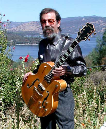 Mike Wilhelm holding Gretsch guitar, Clear Lake in background