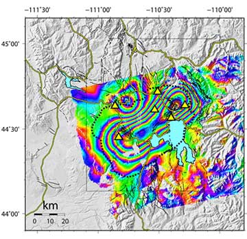 This interferogram provides a map view of ground movements at Yellowstone. Each color contour represents a line of equal uplift relative to the ENVISAT  satellite between Sept. 2004 and Aug. 2006. The center of the uplift is an elliptical region stretching from the northeastern part of the Yellowstone Caldera (the dashed black line) to the southwest. This area of maximum uplift encompasses both Yellowstone's resurgent domes, features long known for similar movements. During this time period, the north-rim uplift anomaly subsided (bullseye in the upper left part of the interferogram). The yellow lines are roads. The yellow triangles are locations of GPS stations with continuous data. The light blue lake within the caldera is Yellowstone Lake. Thin black lines are mapped faults. Figure courtesy of C. Wicks, USGS.